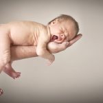 Nyfødt baby gaber I fars arme hos fotografen i Nordsjælland
